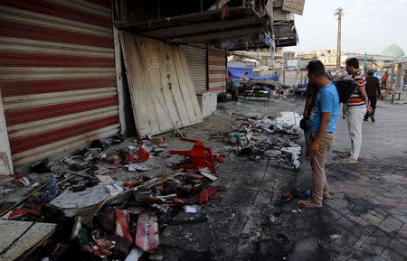 People inspect the site of car bomb in New Baghdad, July 22, 2015. REUTERS/Khalid al-Mousily