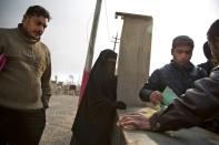 Iraqis wait to receive official documents outside the Qayyarah tribunal on December 6, 2016