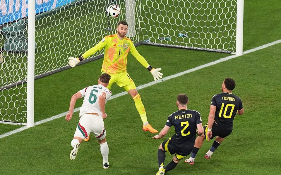 Hungary's Willi Orban (6) heads the ball over Scotland's goalkeeper Angus Gunn during a Group A match