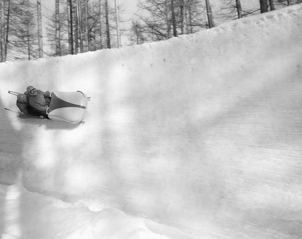 FILE - In this Jan. 27, 1956 filer, driver Eugenio Monti of Italy, shown piloting his sled in a trial run, was in second place at the halfway mark of the two-man bobsled championship of the winter Olympic Games, at Cortina D'Ampezzo, Italy. The Cortina track was built in 1923 and the resort known as the “Queen” of the Italian Dolomites was home to bobsledding great Eugenio Monti, who won six Olympic medals between 1956 and 1968. (AP Photo)