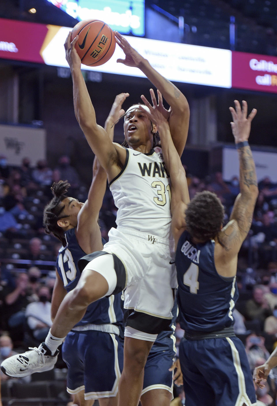 Wake Forest's Alondes Williams drives to the basket between Charleston Southern's Tahlik Chavez (13) and Deontaye Buskey during the first half of an NCAA college basketball game Wednesday, Nov. 17, 2021, in Winston-Salem, N.C. (Walt Unks/The Winston-Salem Journal via AP)