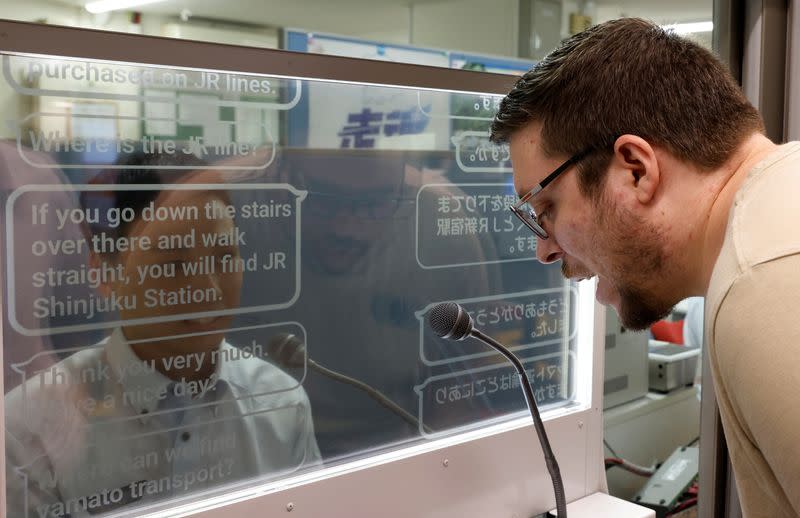 Austrian tourist Georg Riedlbaur uses an automated translation window at the Seibu-Shinjuku station in Tokyo