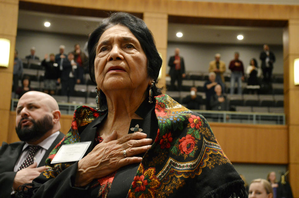 FILE - In this Feb. 27, 2019, file photo, Dolores Huerta, the Mexican-American social activist who formed a farmworkers union with Cesar Chavez, stands for the Pledge of Allegiance in Spanish while visiting the New Mexico Statehouse in Santa Fe. N.M. The picturesque northern New Mexico birthplace of Huerta and the site of one of the worst mining disasters in U.S. history is up for sale. (AP Photo/Russell Contreras)