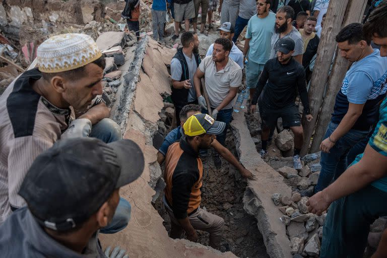 Las personas buscan entre los escombros de las viviendas en la aldea montañosa de Imi N'Tala, al sur de Marrakech, el 10 de septiembre de 2023.