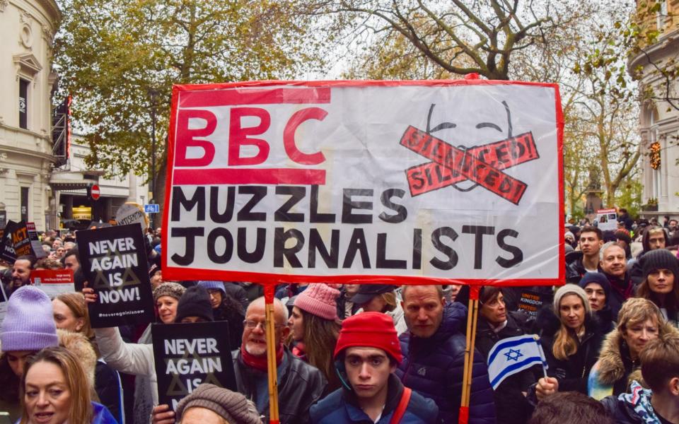 A protester holds a sign criticising the BBC as thousands of pro-Israel supporters marched in Central London against antisemitism