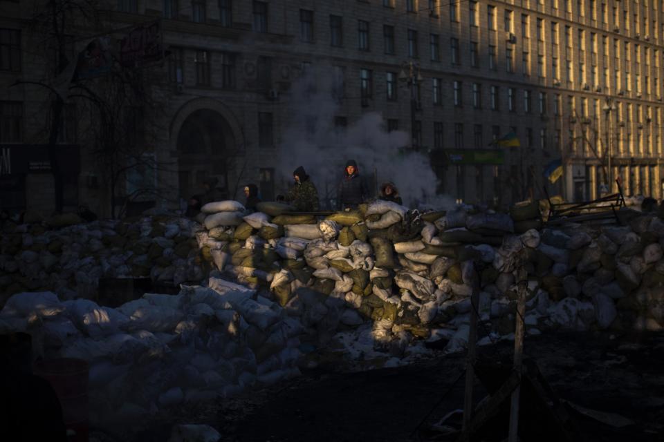 Opposition supporters stand guard on top of a barricade made with sacks of frozen water, blocking a street near Kiev's Independence Square, the epicenter of the country's current unrest, Ukraine, Friday, Jan. 31, 2014. Ukraine's embattled president Viktor Yanukovych is taking sick leave as the country's political crisis continues without signs of resolution. (AP Photo/Emilio Morenatti)