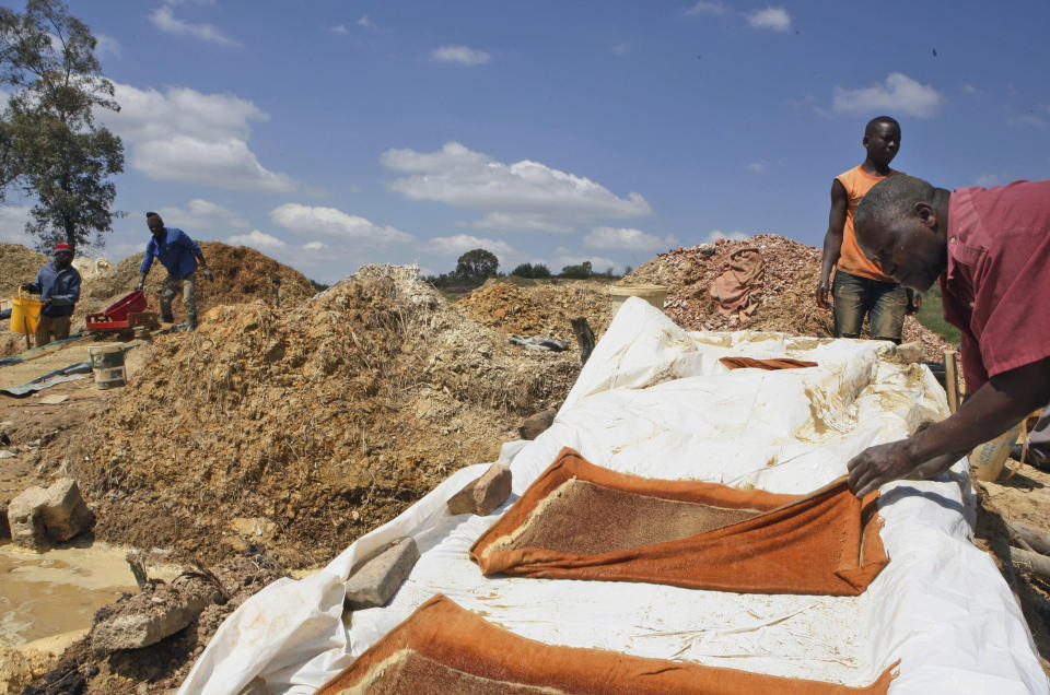 In this Friday Nov. 2, 2012 photo an unidentified man lays bath towels on a conveyer to catch particles during their illegal gold mining in Roodepoort, South Africa. South Africa’s abandoned gold mines provide many of the country’s unemployed and immigrants with ways to earn money when odd jobs don’t provide a sustainable living. With an increased unemployment rate of 25.5 percent, many turn to illegal gold mining off a main road outside Johannesburg which hosts dozens of men hoping to strike it rich. (AP Photo/Themba Hadebe)