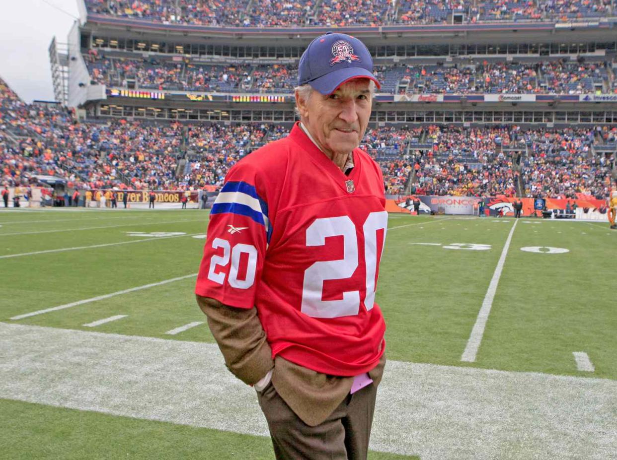 The New England Patriots legend Gino Cappelletti stands on the sidelines for the ceremonial coin toss before their game against the Denver Broncos at Invesco Field on Sunday, Oct. 11, 2009