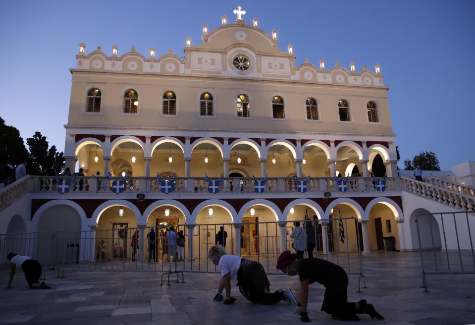 Pilgrims crawl in front of the Holy Church of Panagia of Tinos, on the Aegean island of Tinos, Greece, on Friday, Aug. 14, 2020. For nearly 200 years, Greek Orthodox faithful have flocked to Tinos for the August 15 feast day of the Assumption of the Virgin Mary, the most revered religious holiday in the Orthodox calendar after Easter. But this year there was no procession, the ceremony _ like so many lives across the globe _ upended by the coronavirus pandemic. (AP Photo/Thanassis Stavrakis)