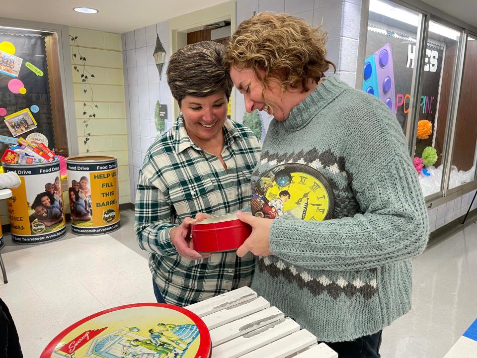 Michelle Patterson and Mendy Goss discuss a candle handmade from Beamery Farm Candles at the annual Holiday Market on Nov. 16 at Hardin Valley Elementary School.