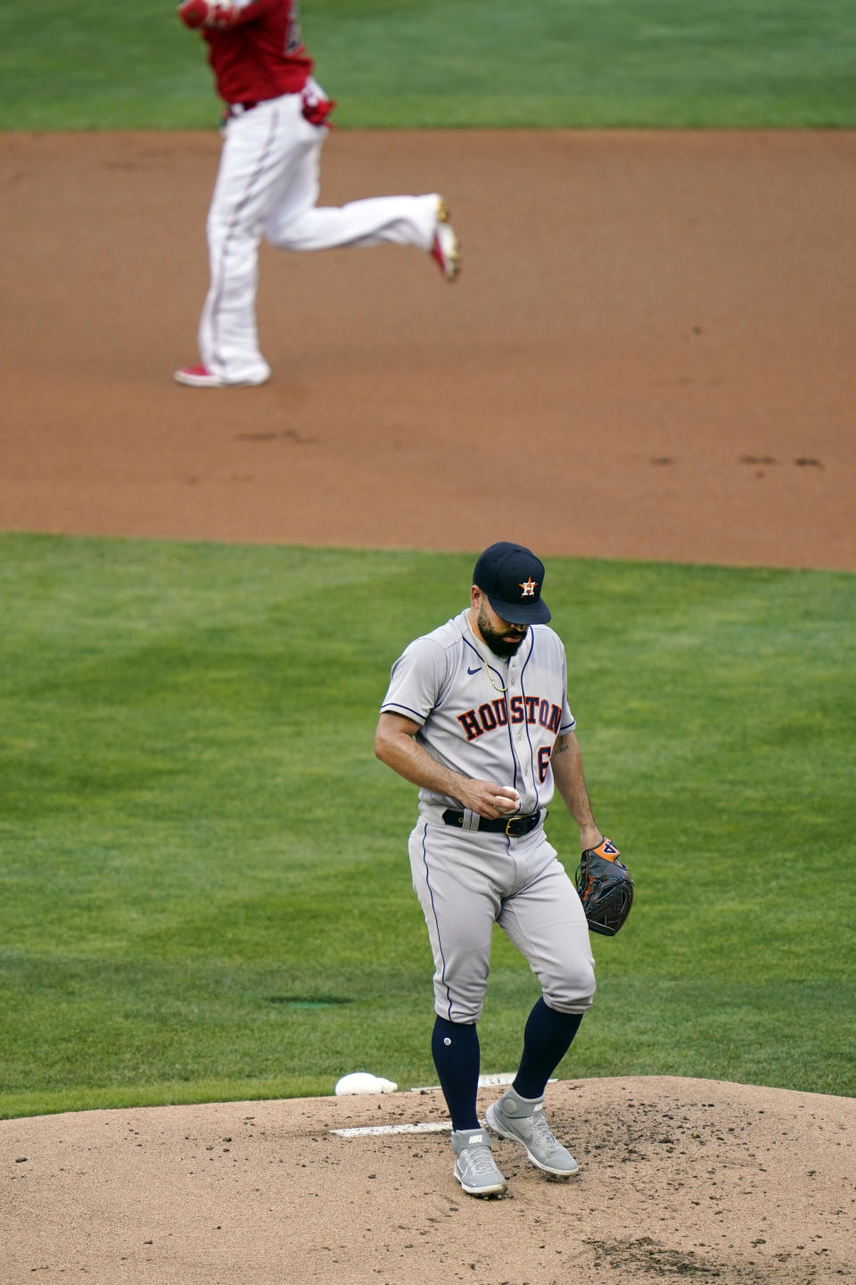 Houston Astros pitcher Jose Urquidy, bottom, racts after giving up a solo home run to Minnesota Twins' Nelson Cruz, top, in the first inning of a baseball game, Friday, June 11, 2021, in Minneapolis. (AP Photo/Jim Mone)