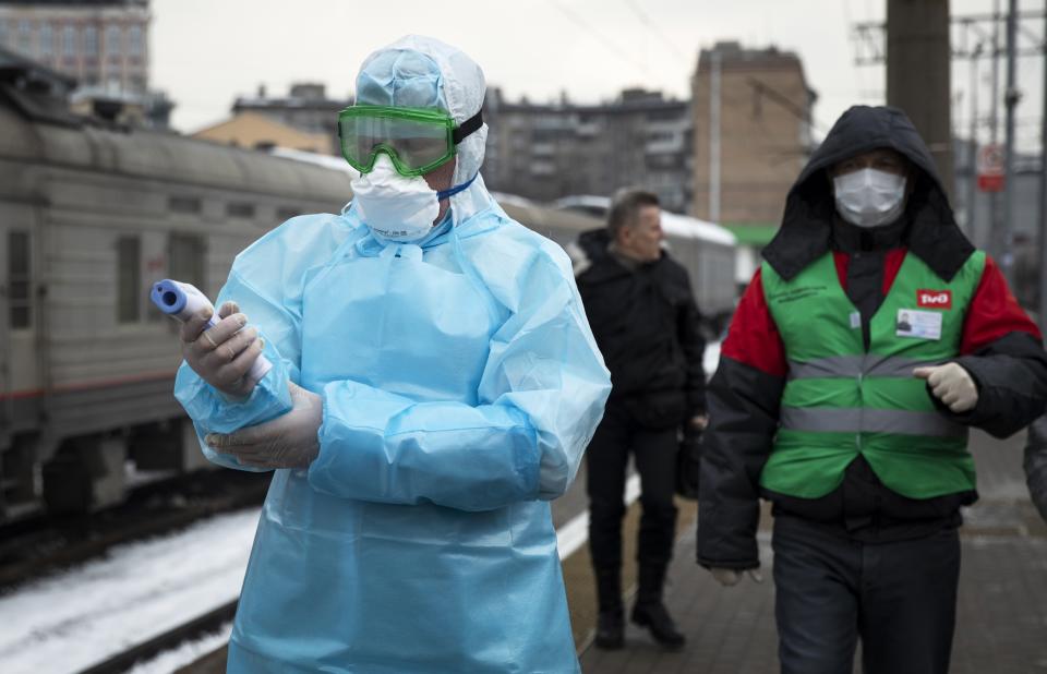 In this file photo taken on Friday, Jan. 31, 2020, Medical workers prepare to check passengers arriving from Beijing at the Yaroslavsky railway station in Moscow, Russia. Russian authorities are going to great lengths to prevent the new coronavirus from spreading in the capital and elsewhere. In Moscow, city officials announced a slew of policies aimed at tracking down the few Chinese nationals remaining in the city, including raids on hotels and the use of facial recognition technology to target people evading quarantine. (AP Photo/Pavel Golovkin, File)