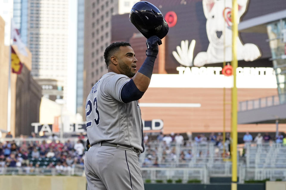 Tampa Bay Rays' Nelson Cruz doffs his helmet to cheering fans before batting in the first inning of a baseball game against the Minnesota Twins, his former team, Friday, Aug. 13, 2021, in Minneapolis. (AP Photo/Jim Mone)