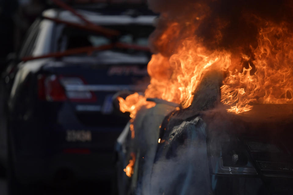 Un coche del Departamento de Policía de Atlanta arde durante una manifestación contra la violencia policial, el 29 de mayo de 2020, en Atlanta. (AP Foto/Mike Stewart)