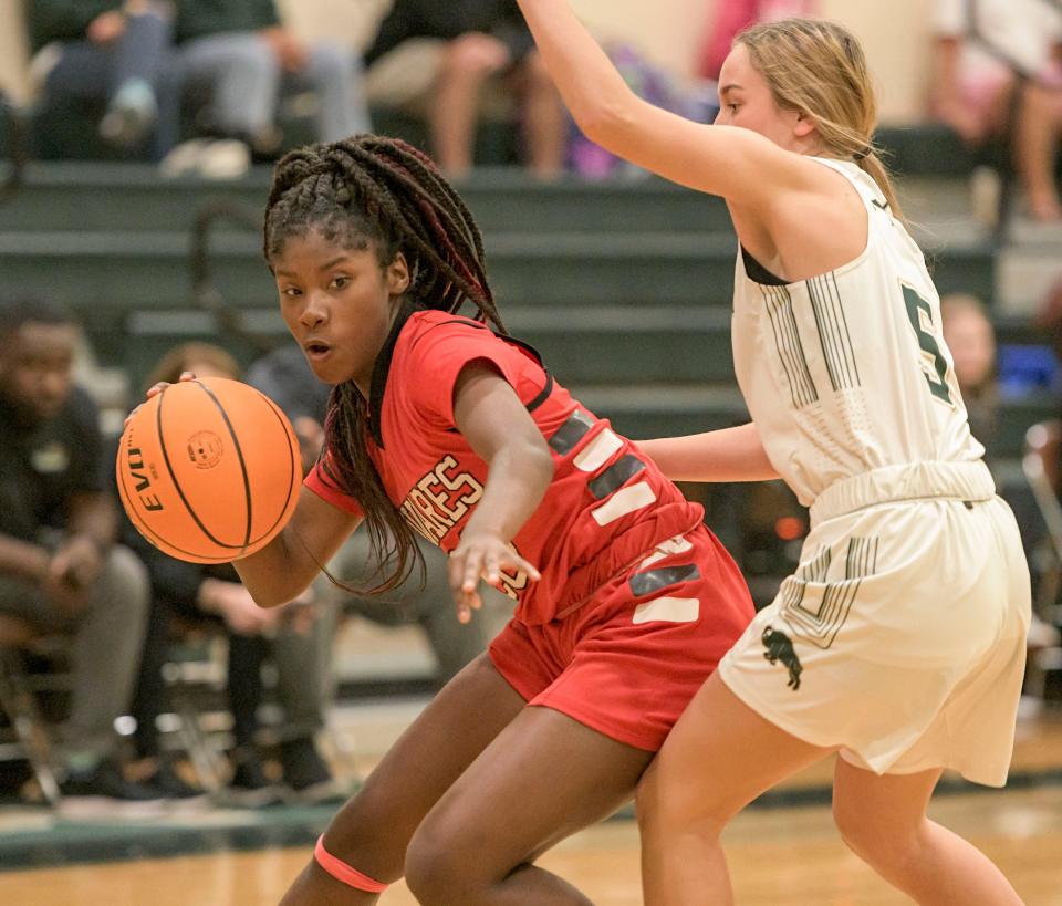 Tavares’ Mari Turney-Jones (20) slips past The Villages’ Emily Calkins (5) during Monday's game at The Villages. Turney-Jones scored a team-high five points. [PAUL RYAN / CORRESPONDENT]