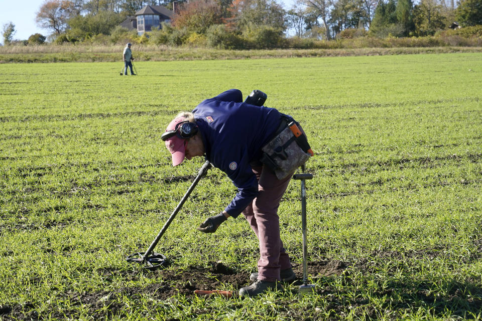Metal detectorist Denise Schoener, of Hanson, Mass., searches for historic coins and artifacts in a farm field in Little Compton, R.I., Thursday, Oct. 27, 2022. One coin at a time, the ground is yielding new evidence that in the late 1600s, Henry Every, one of the world's most ruthless pirates, wandered the American colonies with impunity. Schoener found a 17th century silver coin with Arabic inscriptions in 2019 in a field in Little Compton. (AP Photo/Steven Senne)