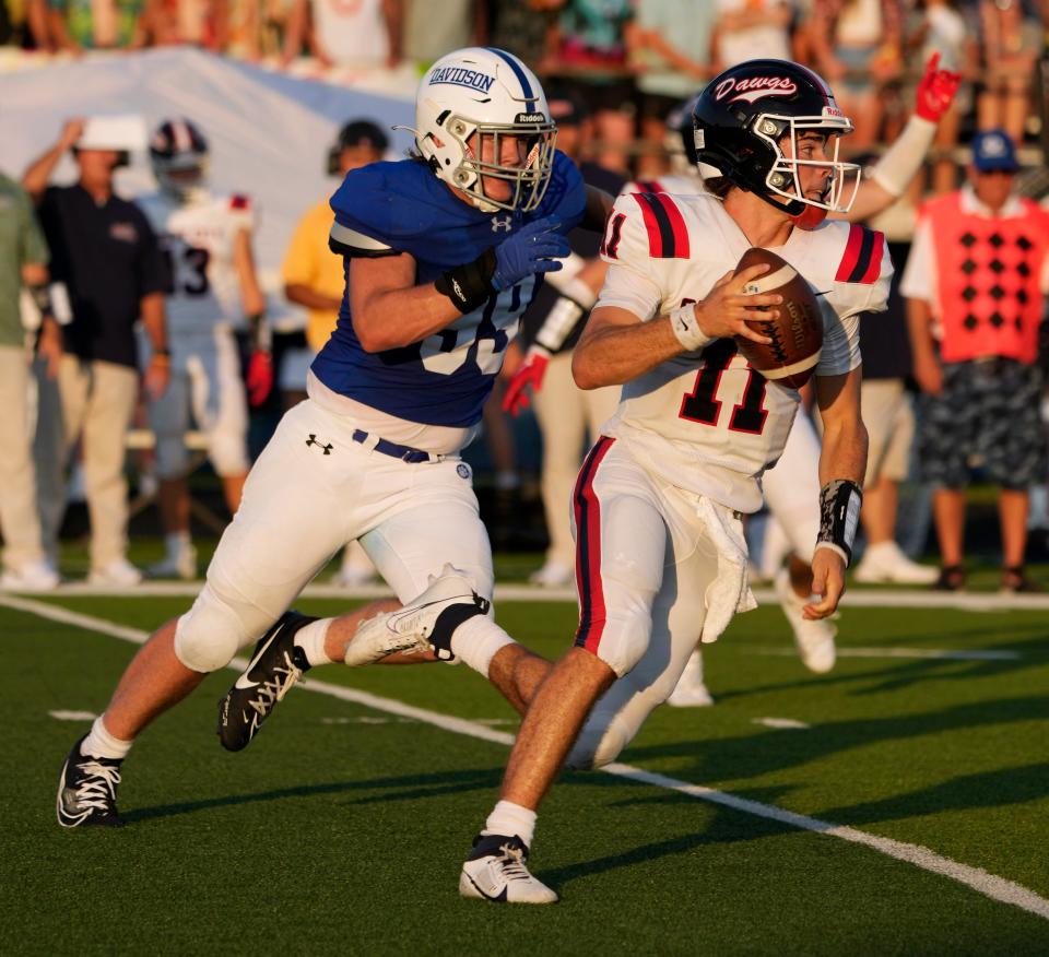 Aug. 25, 2023; Columbus, Oh., USA; 
Quarterback Matthew Papas (11) of Grove City is pursued by Conner Bullen (99) of Davidson during Friday night's football game at Hilliard Davidson High School.