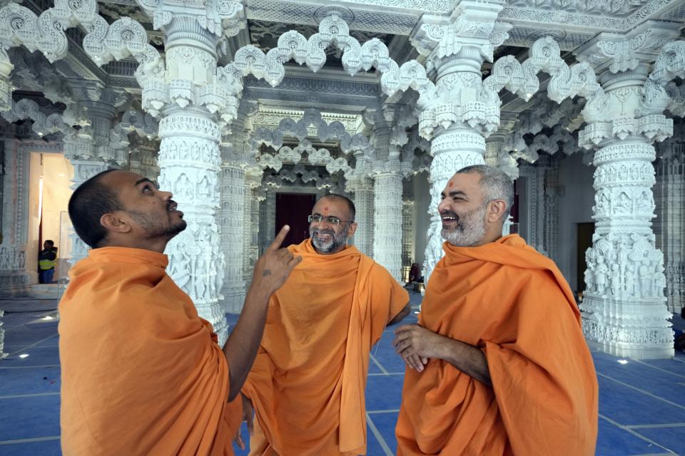 Hindu monks talk to each other at the first stone-built Hindu temple in Abu Mureikha, 40 kms, 25 miles, northeast of Abu Dhabi, United Arab Emirates, Monday, Feb. 12, 2024. The soon-to-open BAPS Hindu Mandir signals just how far the United Arab Emirates has come in acknowledging the different faiths of its expatriate community, long dominated by Indians who power life across its construction sites and boardrooms. (AP Photo/Kamran Jebreili)