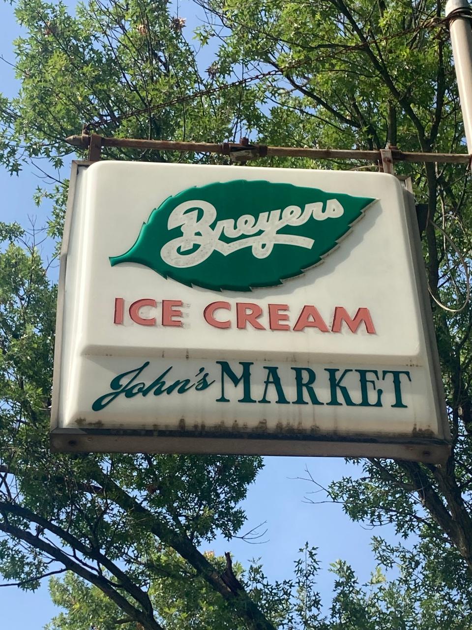 A hanging sign identifies John's Friendly Market at 7th and Station avenues in Haddon Heights.