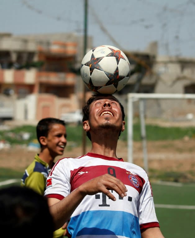 An Iraqi player, sporting the jersey of German club Bayern Munich, shows his skills ahead of a football match in eastern Mosul's al-Salam neighbourhood