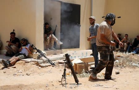 A fighter of Libyan forces allied with the U.N.-backed government fires a mortar during a battle with IS fighters in Sirte, Libya, July 21, 2016. REUTERS/Goran Tomasevic