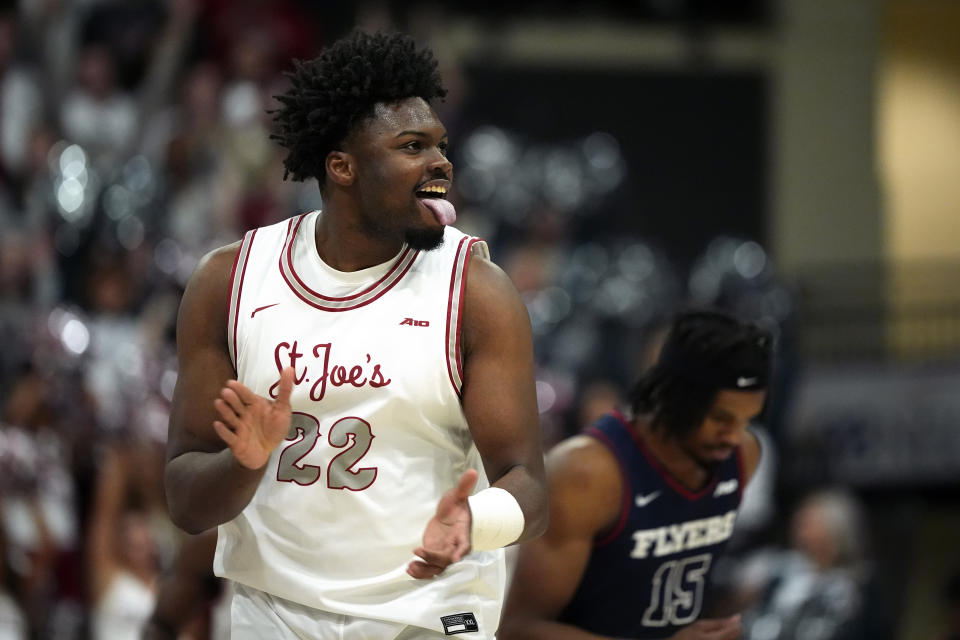 Saint Joseph's Christ Essandoko, left, reacts past Dayton's DaRon Holmes II after making a three-pointer during the first half of an NCAA college basketball game, Tuesday, Feb. 6, 2024, in Philadelphia. (AP Photo/Matt Slocum)