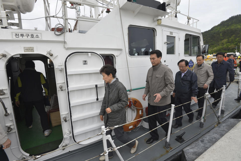 South Korean President Park Geun-hye, left, boards a coast guard vessel at a port of Jindo, South Korea, to head to the site where the ferry Sewol sank in waters off the southern coast, Sunday, May 4, 2014. Park told families of those missing in the sunken ferry that her heart breaks knowing what they are going through, as divers recovered two more bodies on Sunday. (AP Photo/Yonhap) KOREA OUT