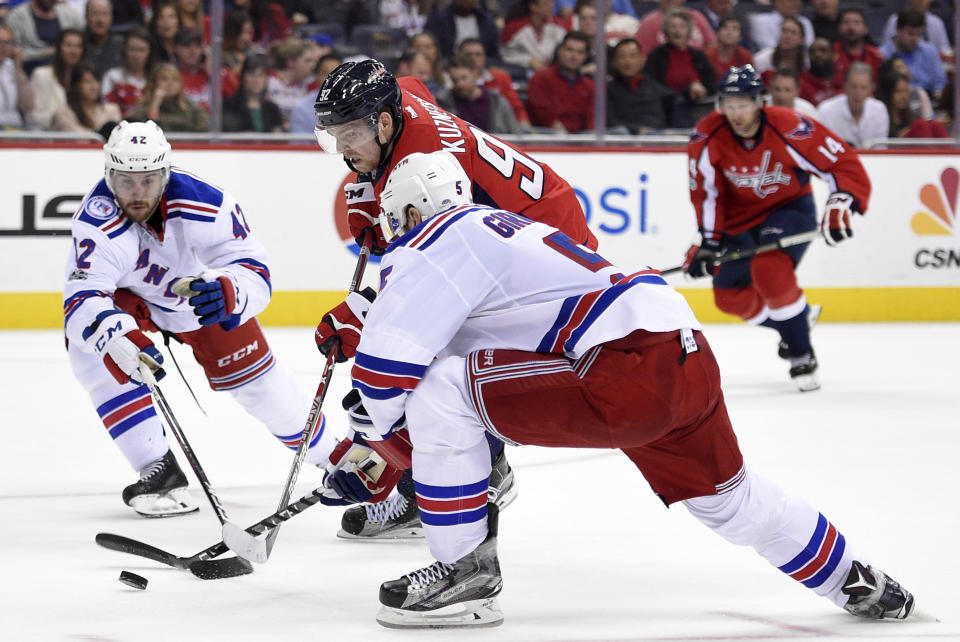 Washington Capitals center Evgeny Kuznetsov (92), of Russia, skates with the puck against New York Rangers defensemen Dan Girardi (5) and Brendan Smith (42) during the second period of an NHL hockey game, Wednesday, April 5, 2017, in Washington. (AP Photo/Nick Wass)