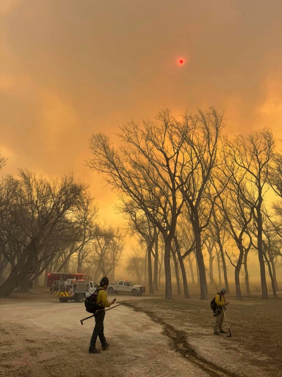 In this photo provided by the Flower Mound, Texas, Fire Department, Flower Mound firefighters respond Tuesday to a fire in the Texas Panhandle. A rapidly widening Texas wildfire doubled in size Tuesday and prompted evacuation orders in at least one small town.