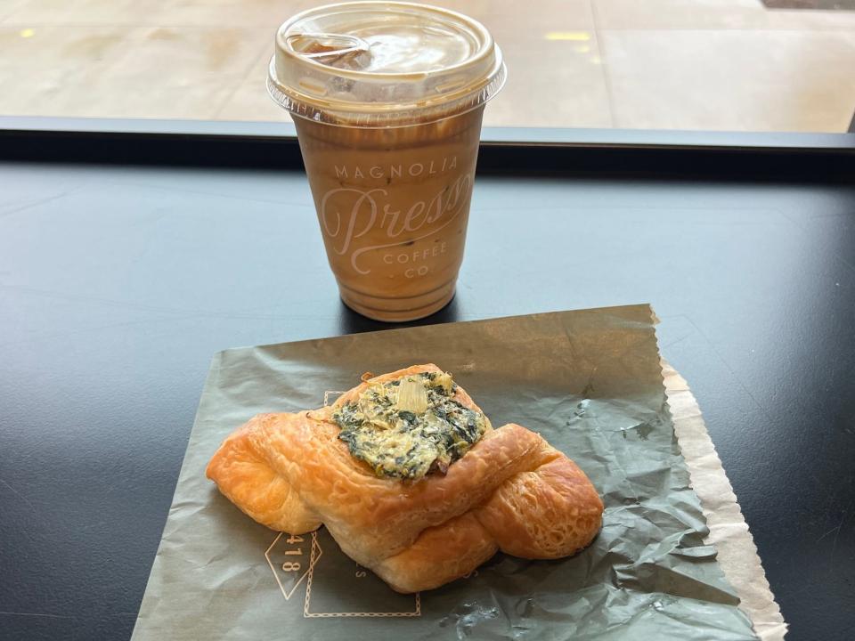 A croissant and an iced coffee on a counter.