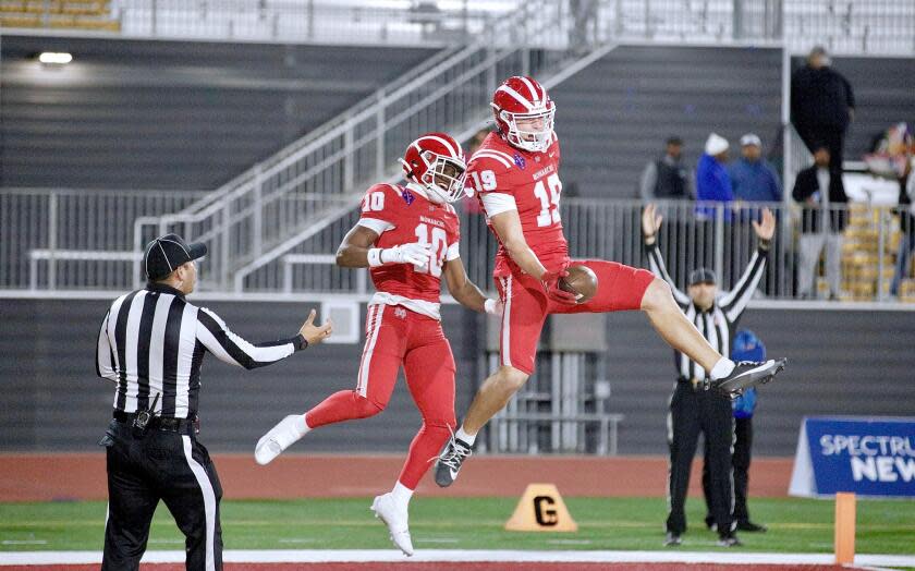 Mark Bowman (19) celebrates with Marcus Harris after after scoring Mater Dei's first touchdown against San Mateo Serra.