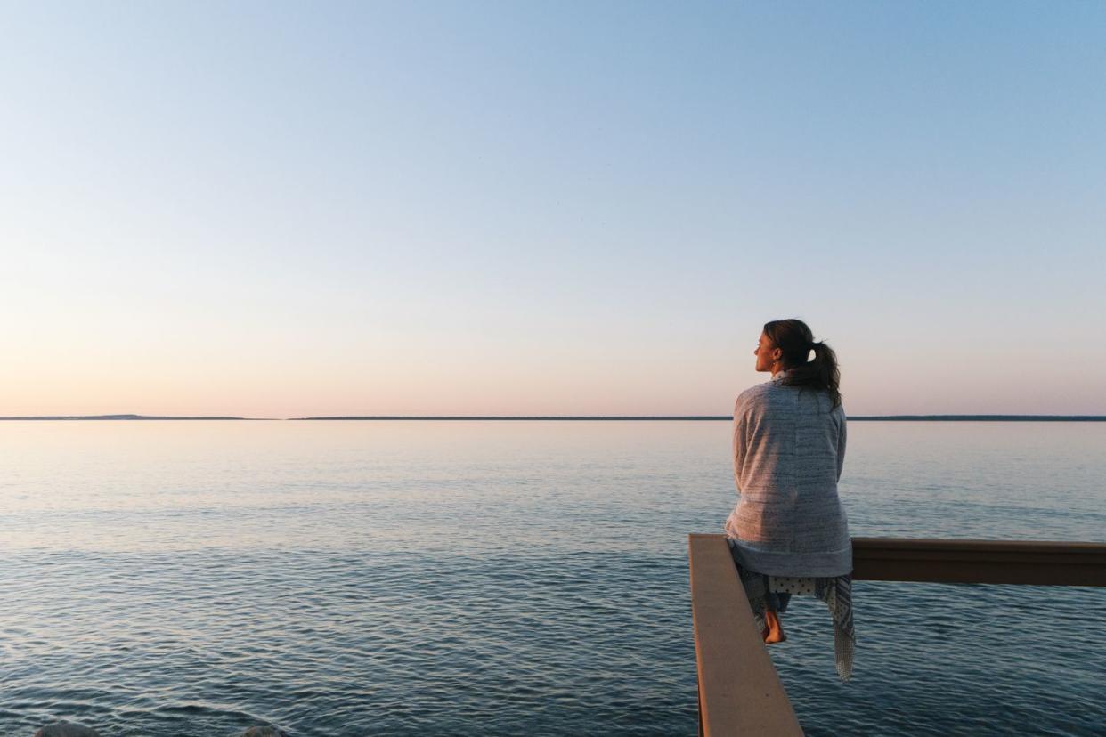 woman sitting on a dock looking out over a body of water