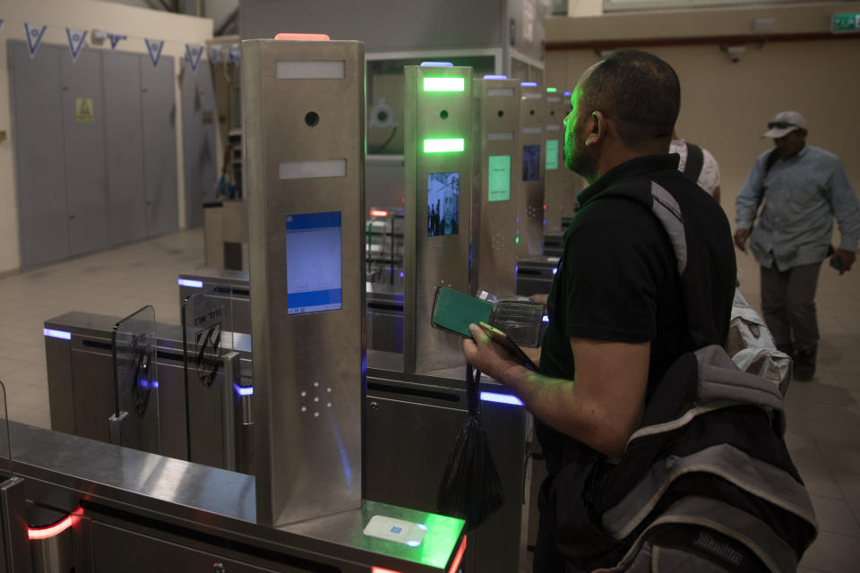 In this Thursday, July 11, 2019 photo, Palestinians stand in front of a biometric gate as they enter Israel at the Qalandia crossing in Jerusalem. Israel’s military has invested tens of millions of dollars to upgrade West Bank crossings and ease entry for Palestinian workers. But while the upgrades may have eased crossing for Palestinians entering Israeli daily for work, critics say they are a sign of the ossification of Israel’s 52-year occupation of the West Bank and slam the military’s use of facial recognition technology as problematic. (AP Photo/Sebastian Scheiner)