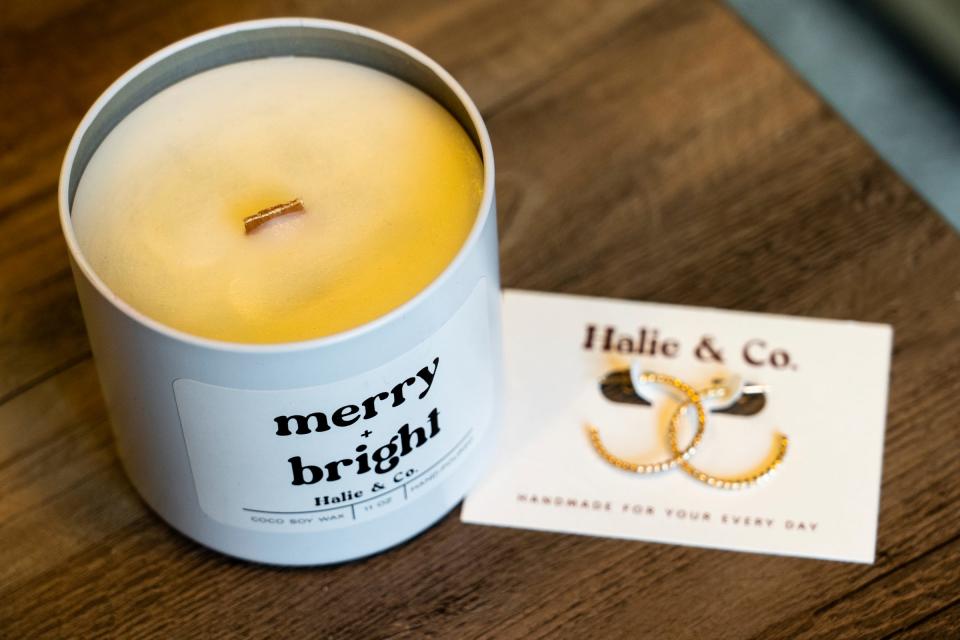 A candle and handmade earrings are shown as gift items for holiday shoppers at the space for Halie & Co. in the Downtown Detroit Markets located at Cadillac Square in downtown Detroit on Wednesday, November 30, 2022.