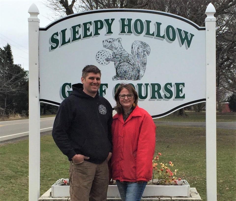 Katelyn and Troy Clapp stand in front of the golf course sign after they purchased Sleepy Hollow.