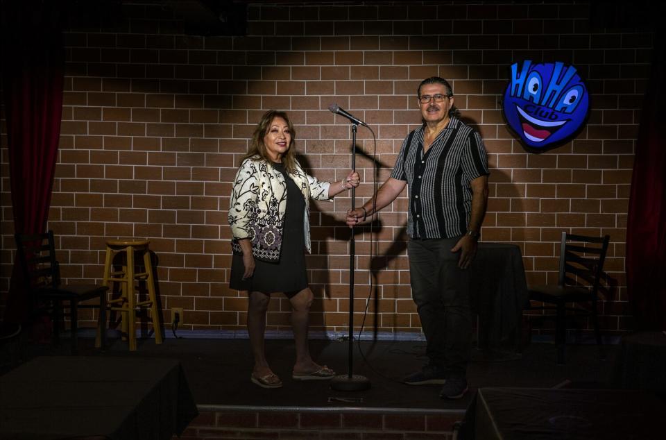 A man and woman holding a microphone onstage