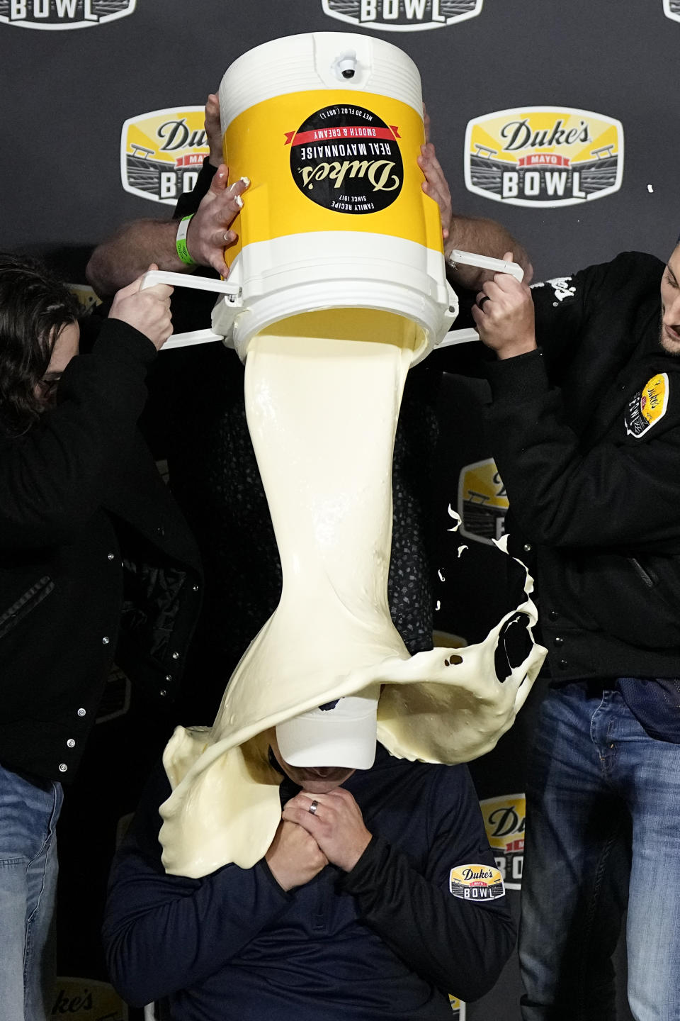 West Virginia head coach Neal Brown gets dunks with mayonnaise after their win against North Carolina in an NCAA college football game at the Duke's Mayo Bowl Wednesday, Dec. 27, 2023, in Charlotte, N.C. (AP Photo/Chris Carlson)