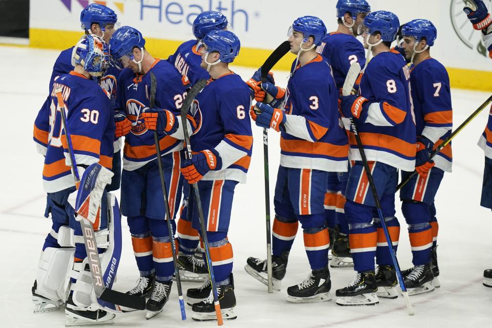 New York Islanders goaltender Ilya Sorokin (30) and Brock Nelson (29) celebrate with teammates after an NHL hockey game against the New Jersey Devils Saturday, May 8, 2021, in Uniondale, N.Y. The Islanders won 5-1. (AP Photo/Frank Franklin II)