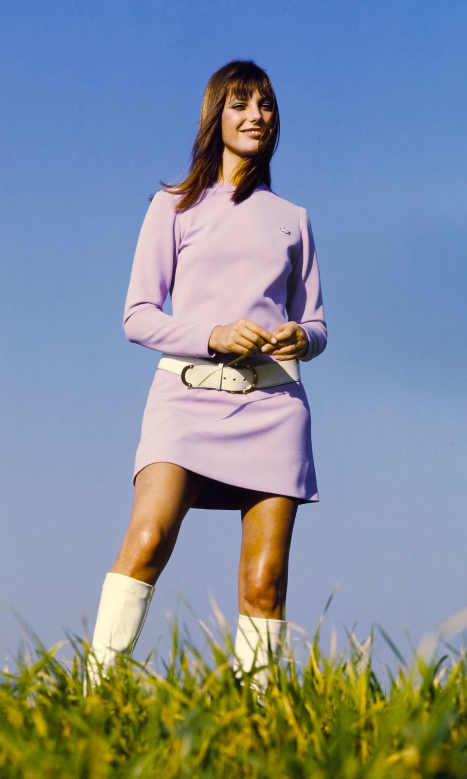 Jane Birkin con vestido corto lila, cinturón y botas blancas
