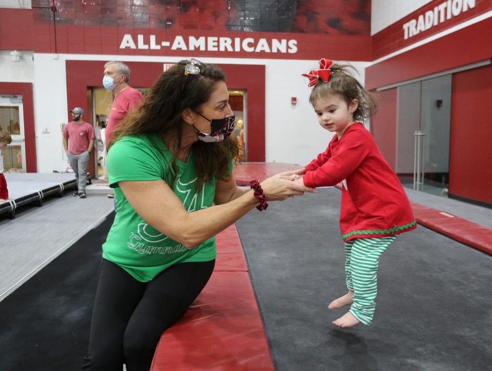 The Crimson Tide gymnastics team hosted the students from Rise Center for their annual holiday celebration Friday, Dec. 3, 2021. Coach Dana Duckworth helps Rise student Lena Laney jump on a runway. [Staff Photo/Gary Cosby Jr]