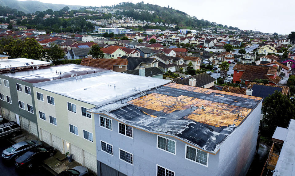 Exposed roofing tops a South San Francisco, Calif., apartment building as storms continue battering the state on Tuesday, Jan. 10, 2023. According to South San Francisco Deputy Fire Chief Matt Samson, squall-like conditions overnight including wind gusts around 70 mph blew roofing material off the building causing water intrusion to two of the apartments. (AP Photo/Noah Berger)