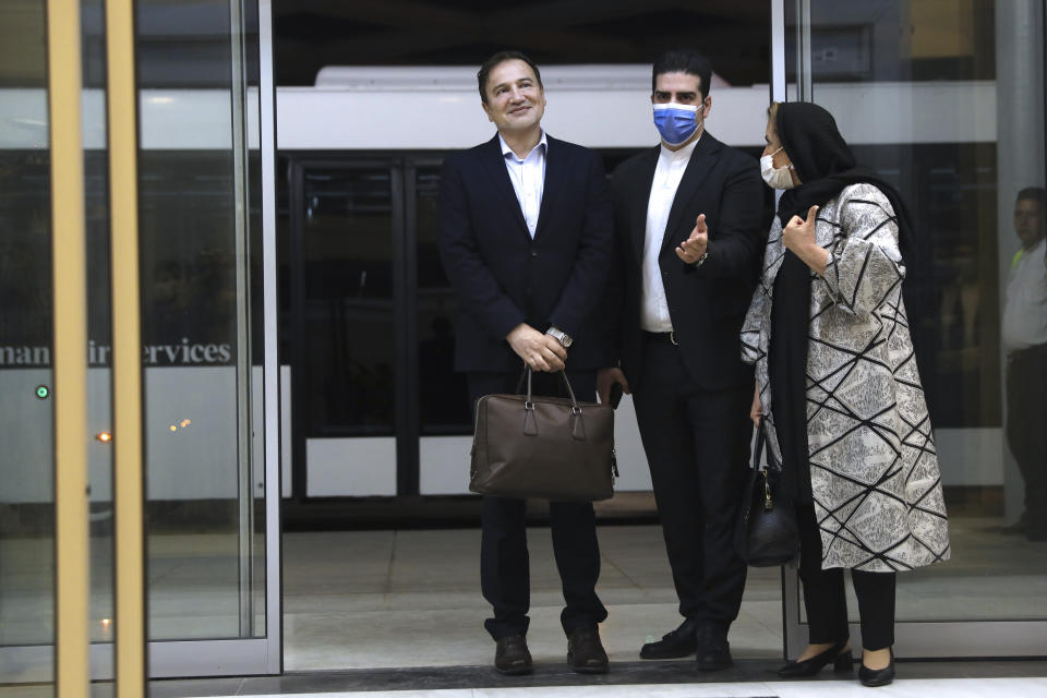 Iranian doctor based in Florida Matteo Taerri, left, is welcomed by an Iranian Foreign Ministry official as his wife stands at right, upon arrival at Tehran's Imam Khomeini Airport from the U.S. after being part of a swap that saw a U.S. Navy veteran held by Iran return to America, Monday, June 8, 2020. Taerri, a dermatologist, had been charged with attempting to export a filter to Iran that he said was for vaccine research but that U.S. authorities said required a license because it could be used for chemical and biological warfare purposes. He was also accused of structuring a series of bank deposits below $10,000 to evade reporting requirements under federal law. (Majid Asgaripour/Mehr News Agency via AP)