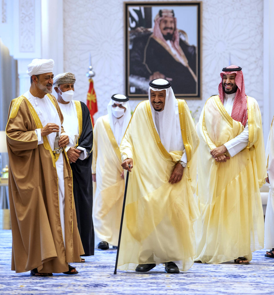 In this photo released by Saudi Royal Palace, Saudi King Salman, center, and Crown Prince Mohammed bin Salman, right, welcome Oman's Sultan Haitham bin Tariq, left, at Neom Royal Palace, in the Tabuk Province of northwestern Saudi Arabia, Sunday, July 11, 2021. Sultan Haitham started the first visit by an Omani ruler in years against the backdrop of renewed diplomatic efforts to end the war in Yemen and the sultanate’s worsening economic woes. A framed photo shows Saudi Arabia's founder, the late King Abdul Aziz Al Saud. (Bandar Aljaloud/Saudi Royal Palace via AP)