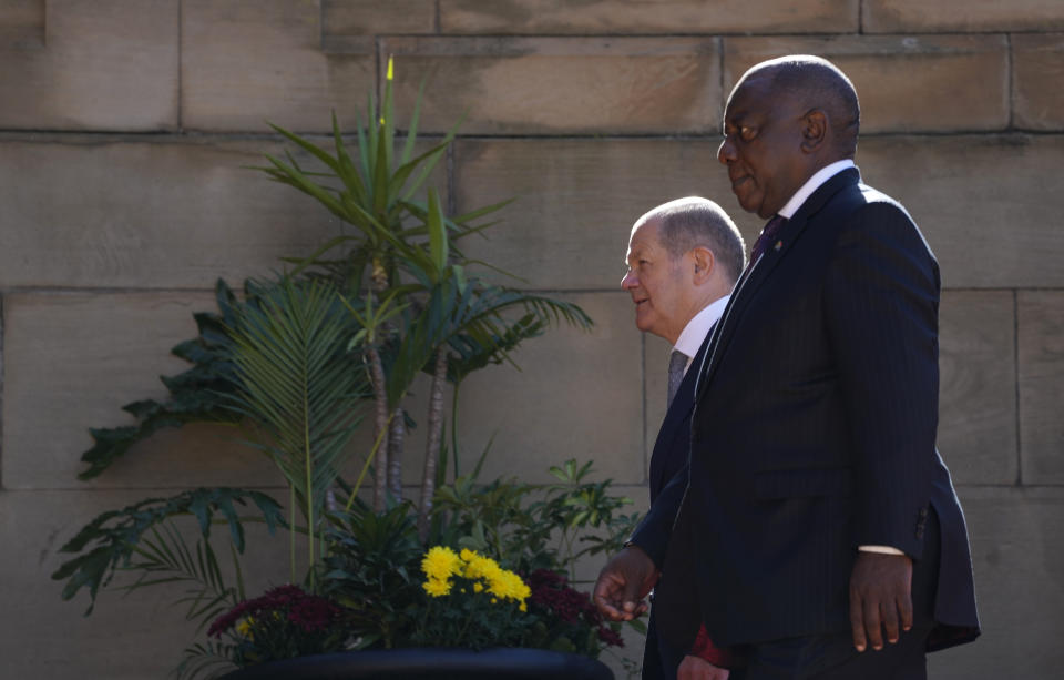 German Chancellor Olaf Scholz, left, walks with South Africa President Cyril Ramaphosa after the official welcoming ceremony at the Union Building in Pretoria, South Africa, Tuesday, May 24, 2022. (AP Photo/Themba Hadebe)