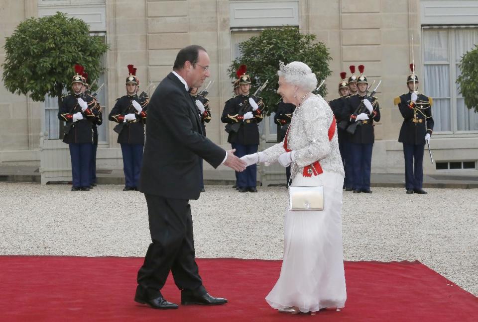 Egal ob beim Kirchgang auf Schloss Windsor, beim Empfang von Frankreichs Staatspräsidenten François Hollande oder zur Feier ihres 90. Geburtstags: Es gibt kaum einen Anlass, bei dem die Queen nicht ohne Handtasche erscheint. Doch wie sie ihre Handtasche trägt ist dabei von großer Bedeutung. (Bild-Copyright: Jaques Brinon/Associated Press)