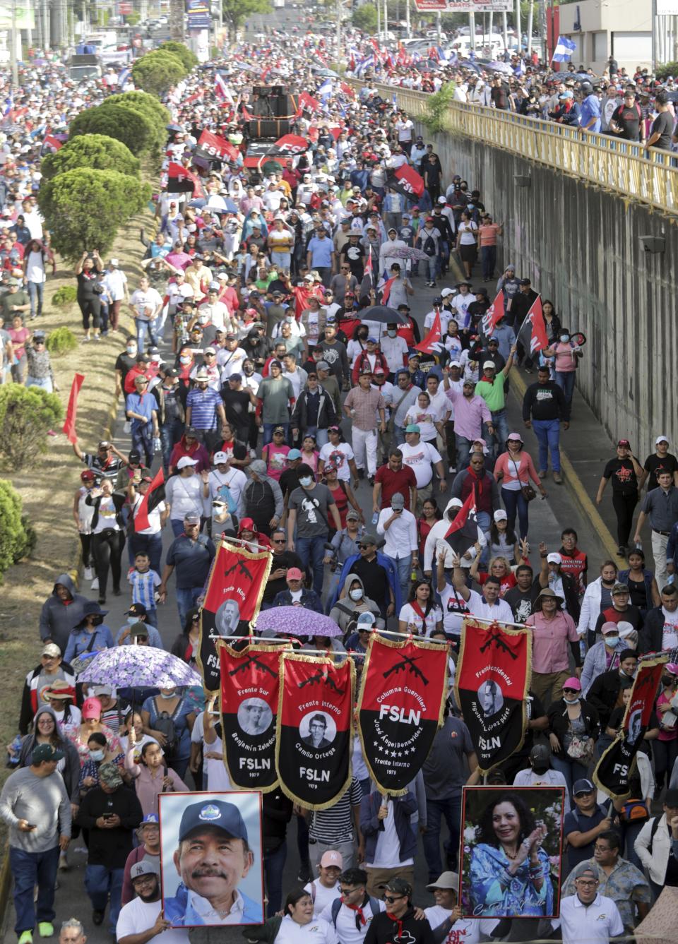 Demonstrators carry Sandinista National Liberation Front banners and a portrait of President Daniel Ortega and Vice President Rosario Murillo, during a pro-government march in Managua, Nicaragua, Saturday, Feb. 11, 2023. (AP Photo)