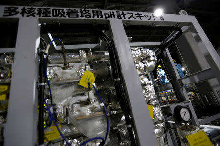Employees of Tokyo Electric Power Co's (TEPCO) wearing protective suits are seen inside a radiation filtering Advanced Liquid Processing Systems, known as ALPS, at tsunami-crippled Fukushima Daiichi nuclear power plant in Okuma town, Fukushima prefecture, Japan February 18, 2019. Picture taken February 18, 2019. REUTERS/Issei Kato