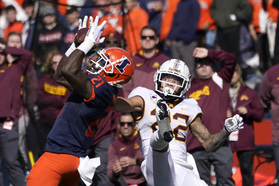 FILE - Illinois defensive back Jartavius Martin (21) intercepts a pass from Minnesota backup quarterback Athan Kaliakmanis intended for wide receiver Michael Brown-Stephens, right, during an NCAA college football game Oct. 15, 2022, in Champaign, Ill. The Washington Commanders continued bolstering their secondary in the second round of the NFL draft Friday, April 28, taking Martin with the 47th pick. Martin, whose given name is Jartavius but prefers to go by Quan, was a five-year starter with the Illini. (AP Photo/Charles Rex Arbogast, File)