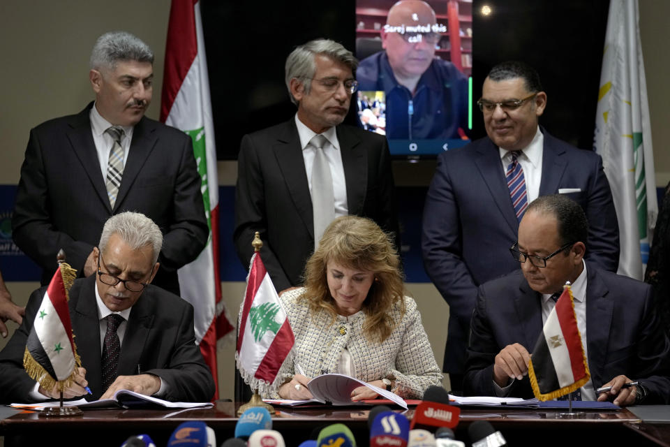 ADDS THAT THE WORLD BANK'S REGIONAL DIRECTOR SAROJ KUMAR JHA LOOKS ON VIA VIDEO -- Seated left to right, Director General of the Syrian General Petroleum Corporation Nabih Khrestin, Director-General of Oil Facilities at Lebanese Energy Ministry Aurore Feghali, and the Chairman of the Egyptian Natural Gas Holding Company (EGAS) Magdy Galal, sign deals to bring gas from Egypt through Syria to Lebanon, as the World Bank's Regional Director Saroj Kumar Jha looks on via video, at the Ministry of Energy and Water in Beirut, Lebanon, Tuesday, June 21, 2022. (AP Photo/Bilal Hussein)