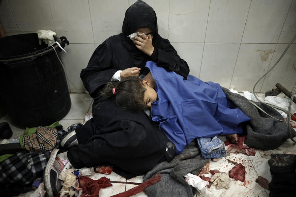 A Palestinian woman cries as she sits next to her wounded girl at the Nasser hospital in Khan Younis, southern Gaza, on Monday, Jan. 22, 2024.  (Mohammed Dahman / AP)